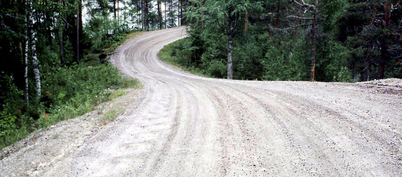 Tiukka S-mutka hiekkaisella kylätiellä